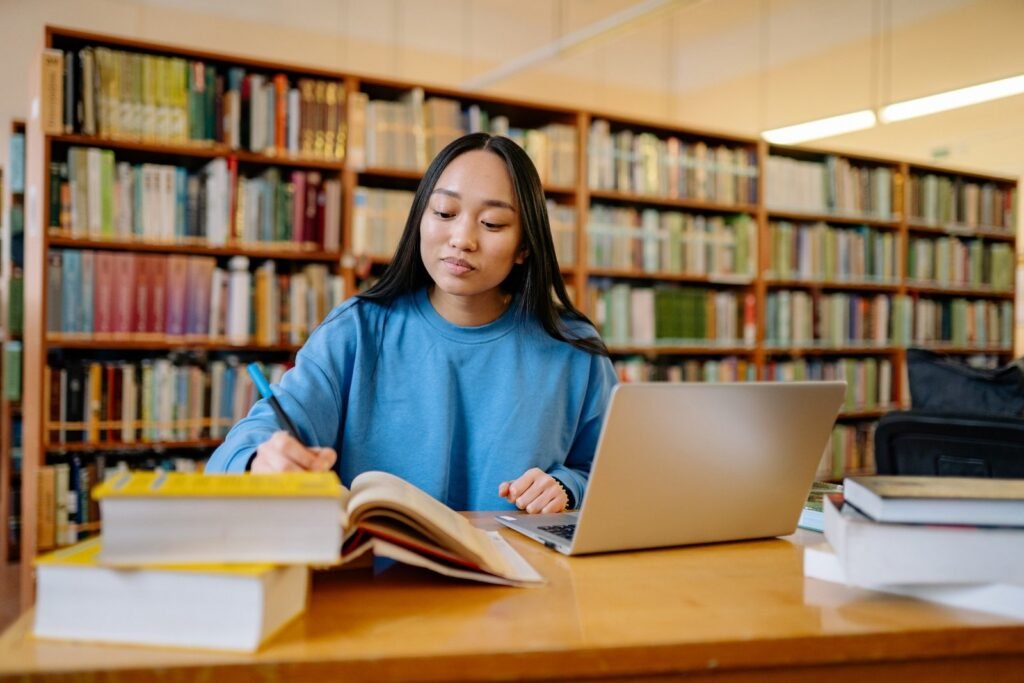 A student at gradate level doing writing at library 
